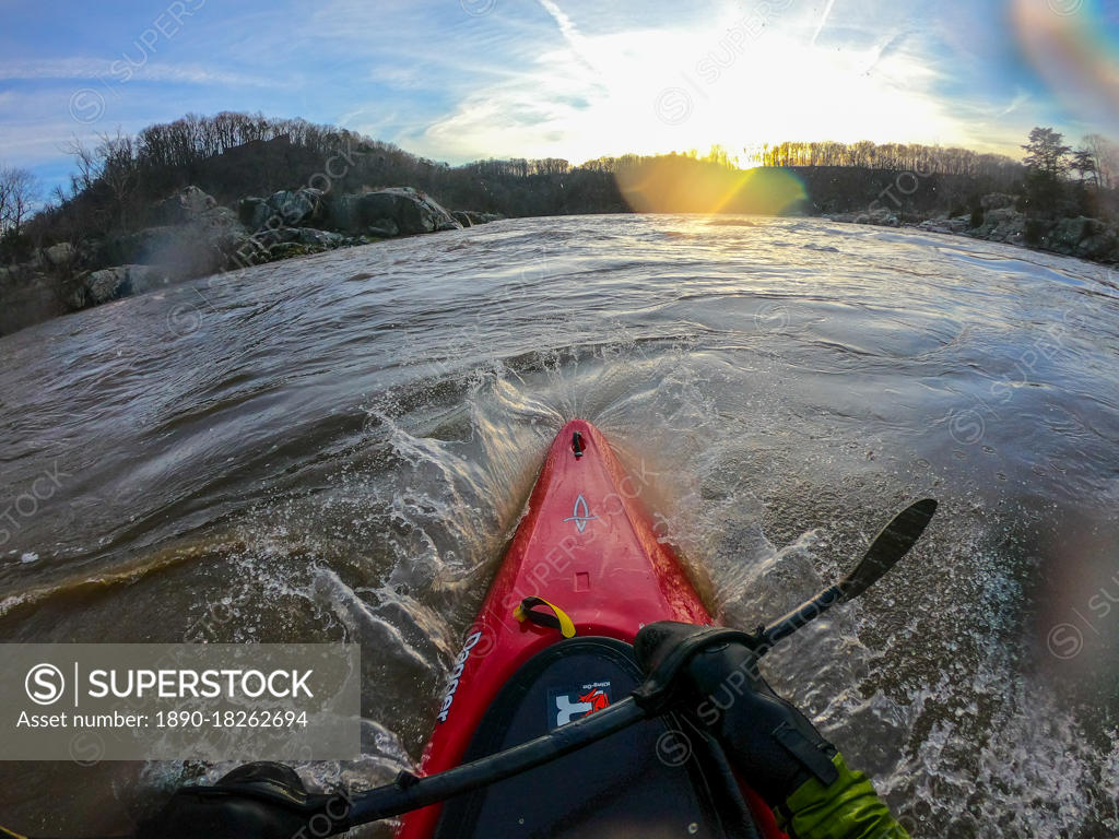 Photographer Skip Brown surfs his kayak on a whitewater wave on the