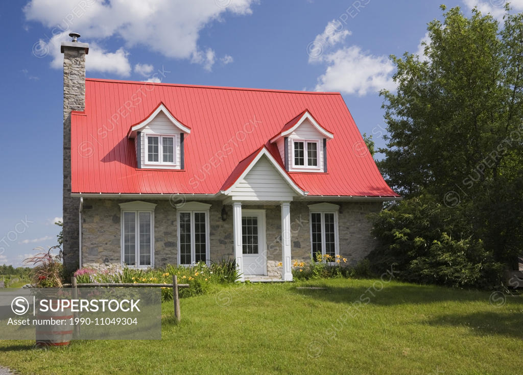 Canadiana cottage style residential fieldstone home in summer, Sainte