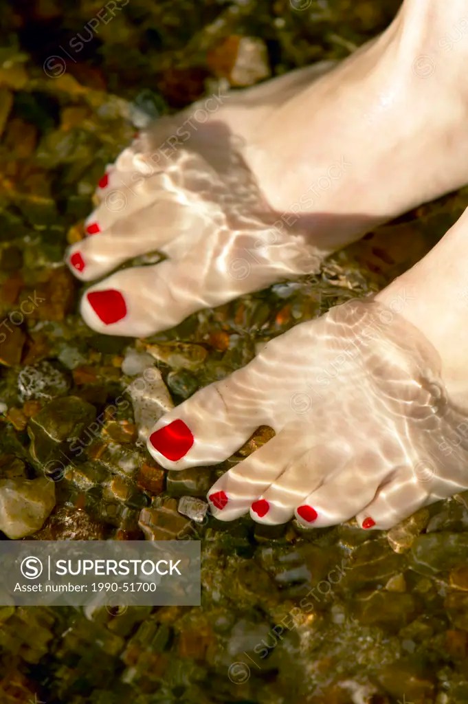 woman´s feet on beach with water and red pedicured toes, Lac Laurel