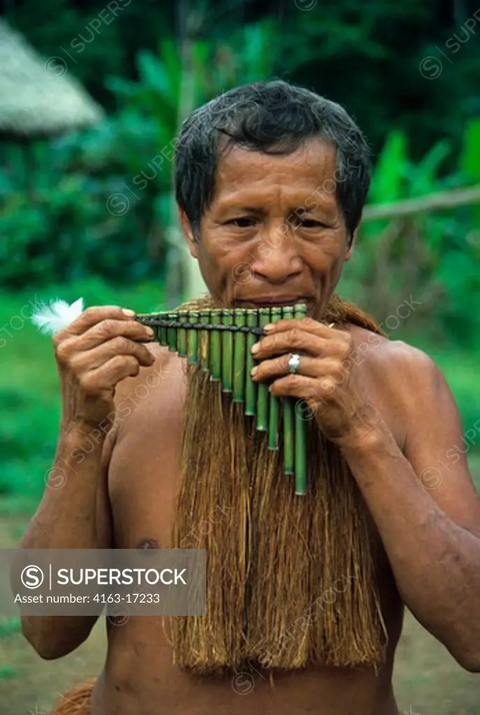 AMAZON RIVER, YAGUA INDIAN PLAYING TRADITIONAL REED FLUTE SuperStock