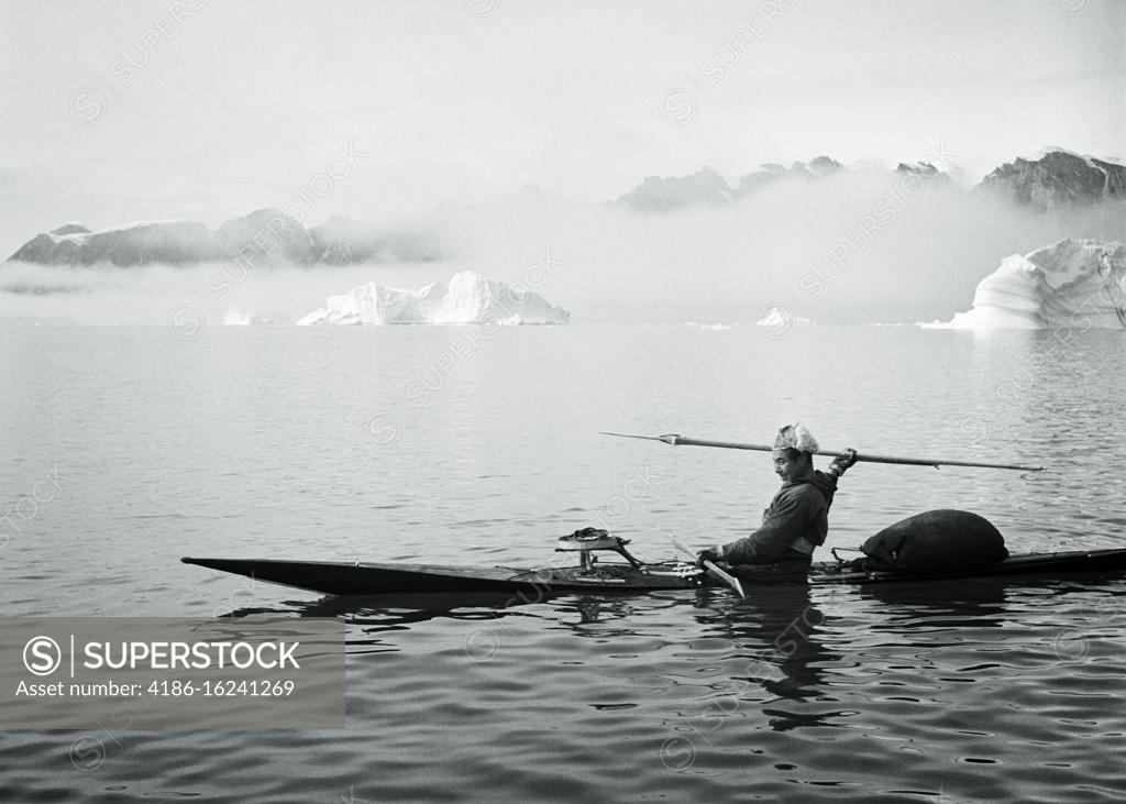 1950s MAN GREENLANDIC INUIT HUNTING HARPOONER IN KAYAK AT SYDKAP IN