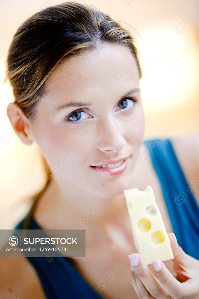 Woman eating gruyere. SuperStock
