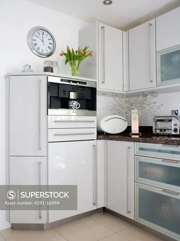 Fitted coffeemachine in modern kitchen with white melamine units