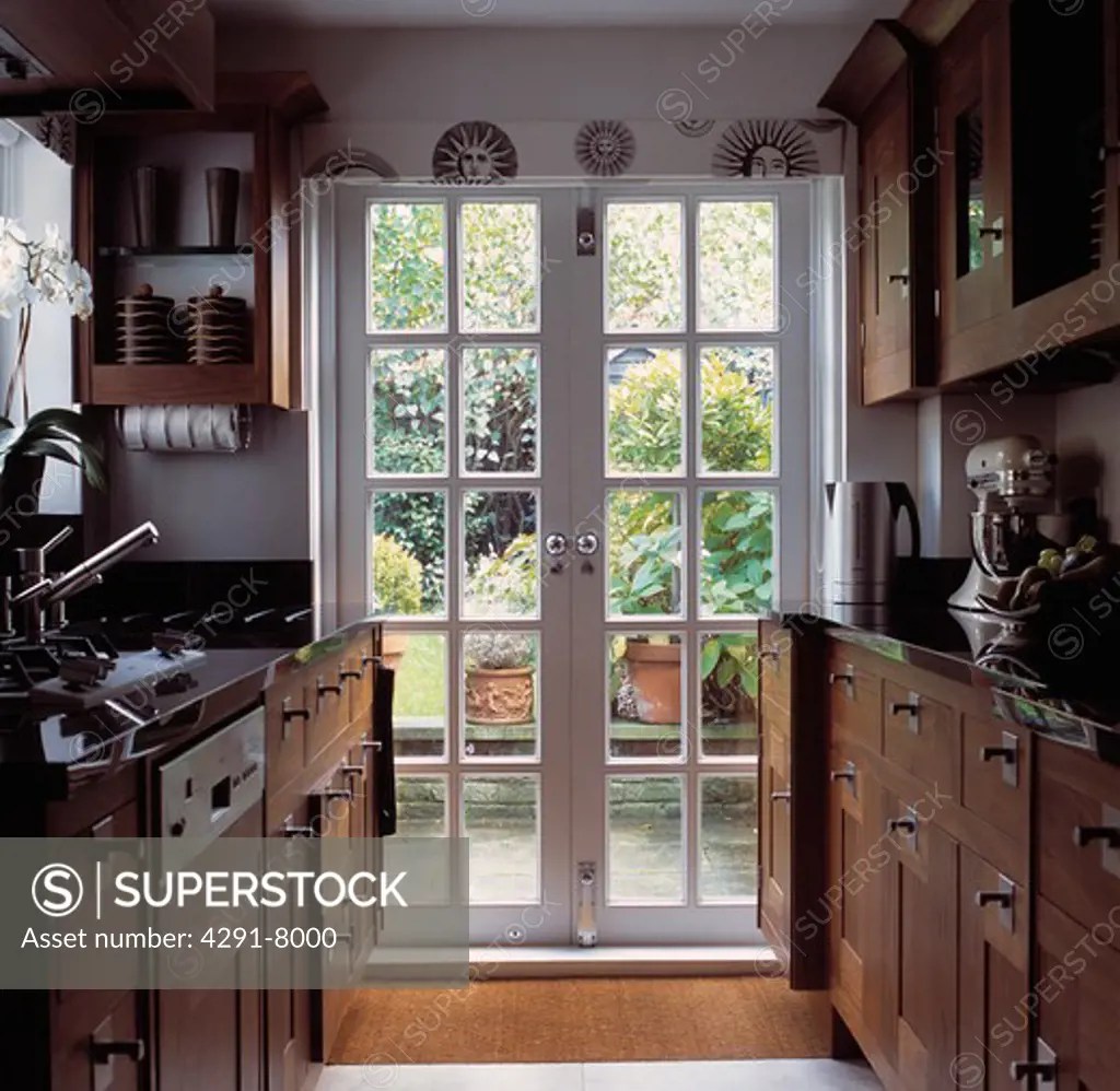 Glazed French doors in traditional galley kitchen with wooden fitted