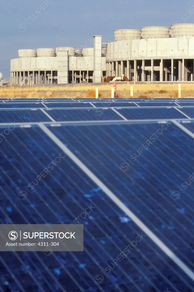Solar panels at White Bluffs Solar Station with nuclear power plant in