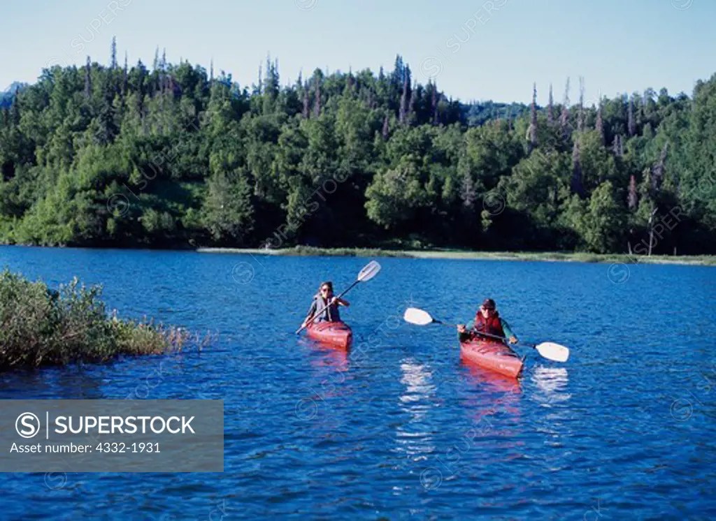 Jennifer Lambourne and John Phelps paddling kayaks on Beaver Lake of