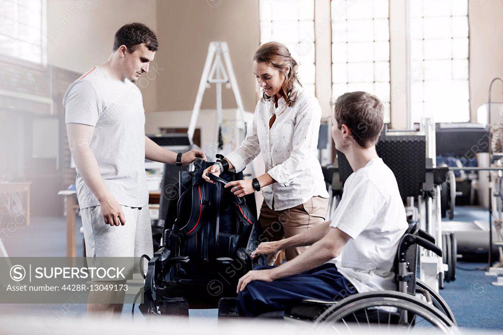 Physical therapists with man in wheelchair SuperStock