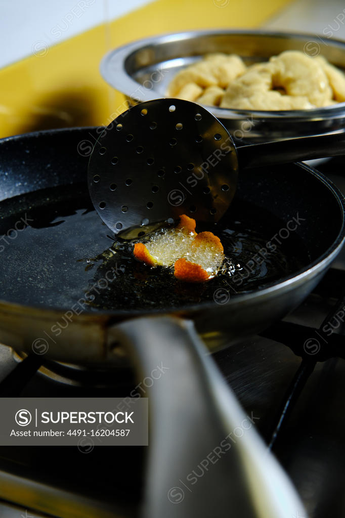 From above bunch of delicious doughnuts frying in hot bubbling oil on