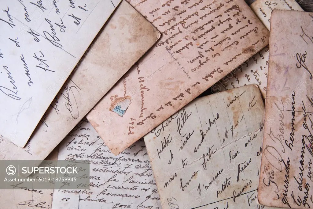 pile of old handwritten letters scattered on the table SuperStock
