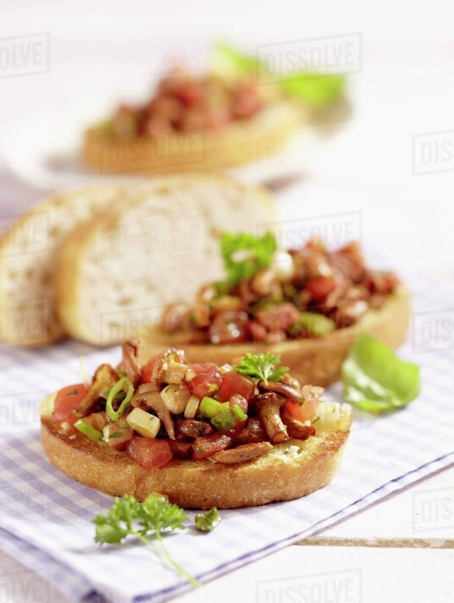 Bruschetta topped with chanterelle mushrooms Stock Photo Dissolve