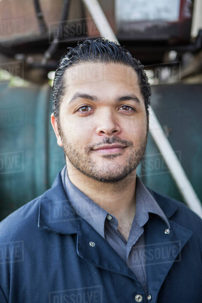 Hispanic blue collar worker smiling outdoors Stock Photo Dissolve