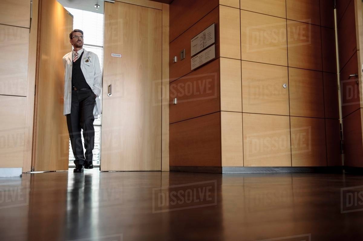 Doctor walking in office hallway Stock Photo Dissolve