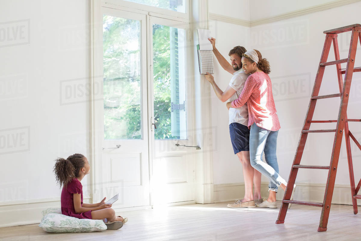 Family fixing up new home together Stock Photo Dissolve