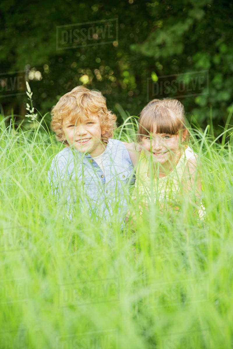 Children playing in tall grass Stock Photo Dissolve