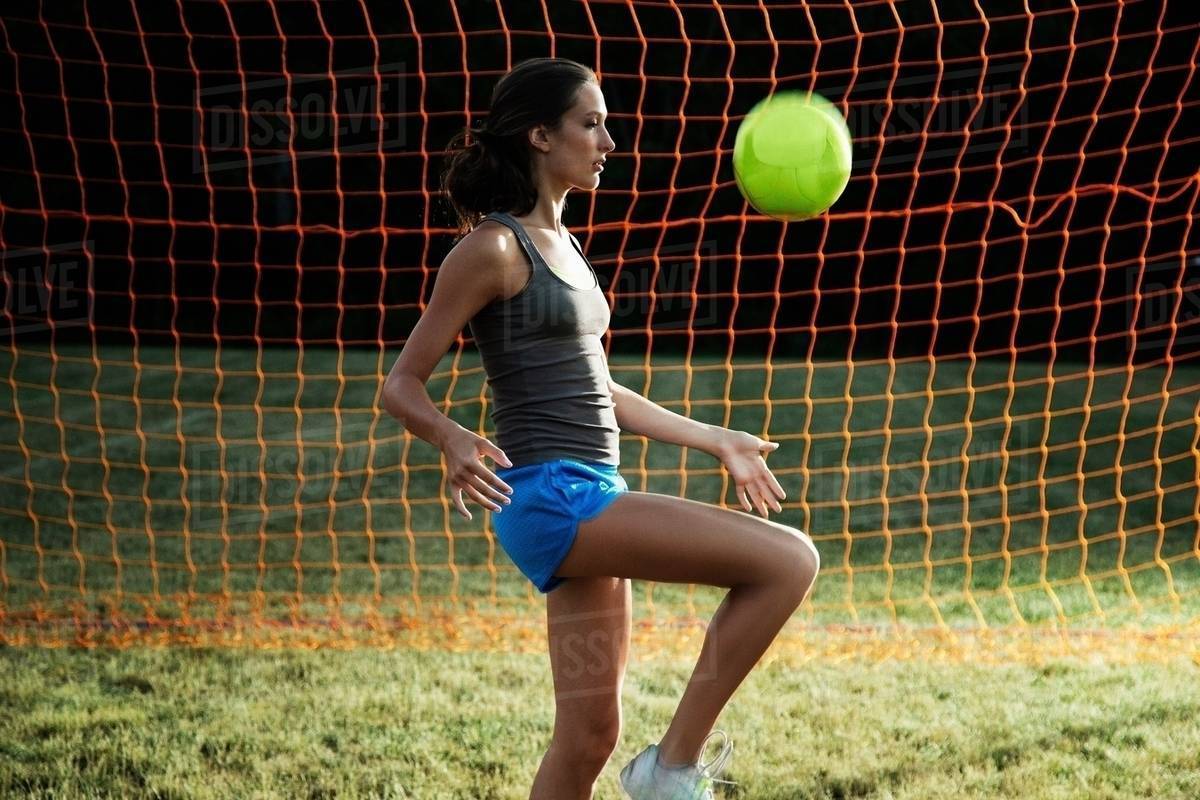 Girl playing keepy uppy with soccer ball Stock Photo Dissolve