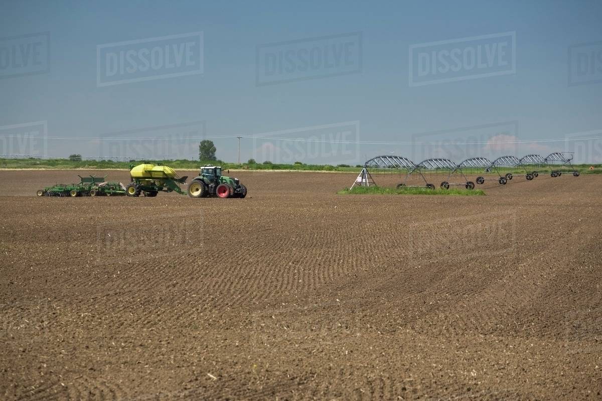 Air Seeder Planting In A Tilled Field; Alberta, Canada Stock Photo Dissolve