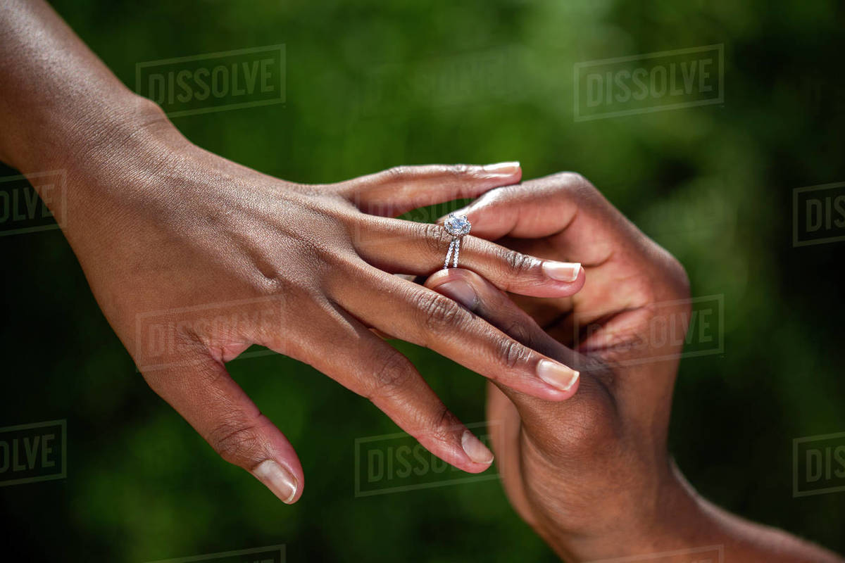 Engagement ring being put on African woman's finger Stock Photo