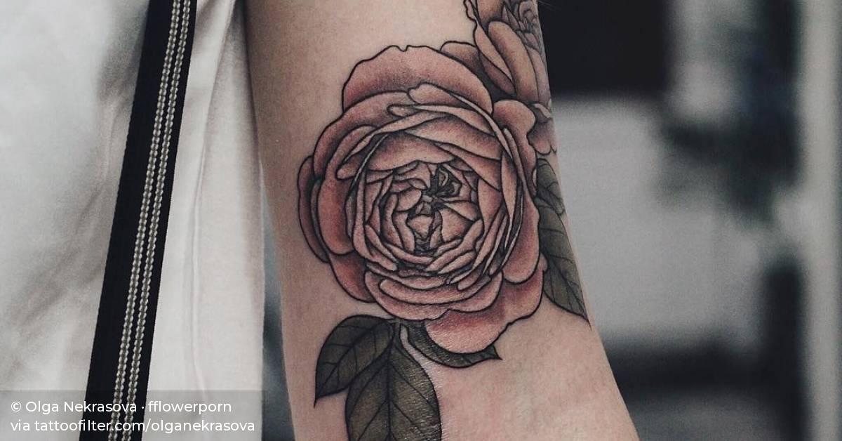 Illustrative pink rose tattoo on the left bicep.