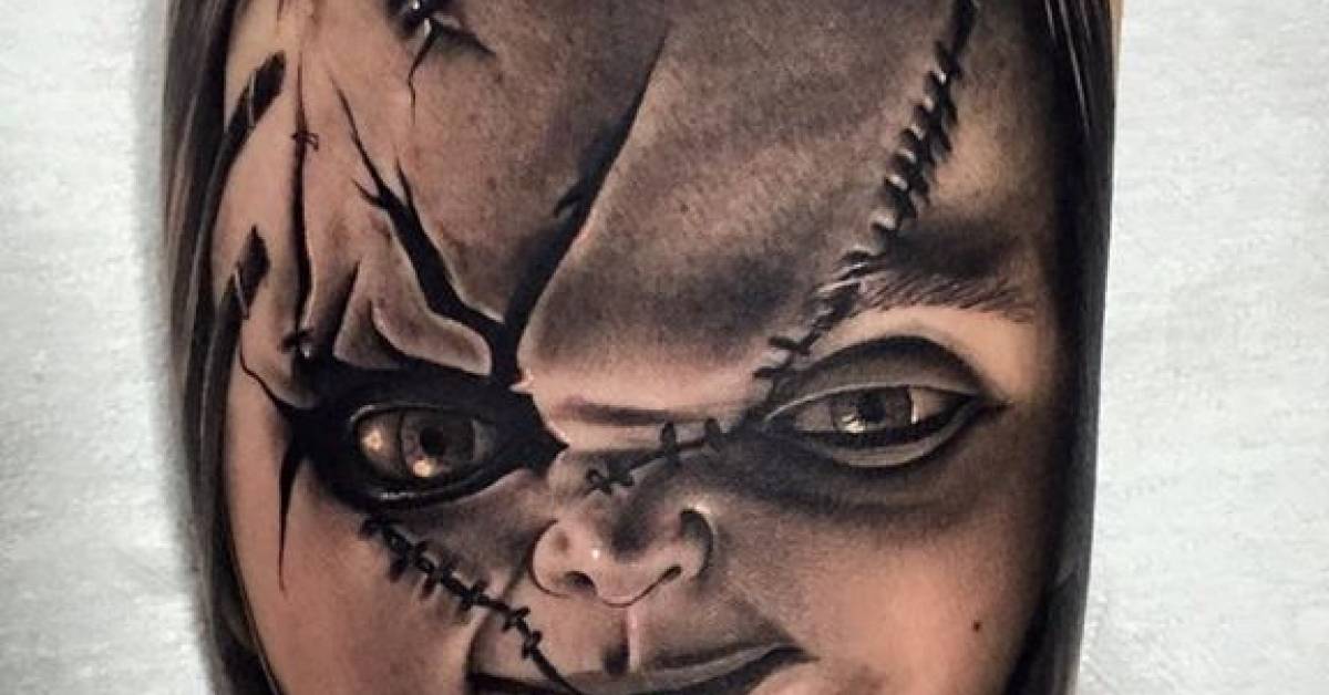 Black and grey Chucky tattoo on the left inner arm.