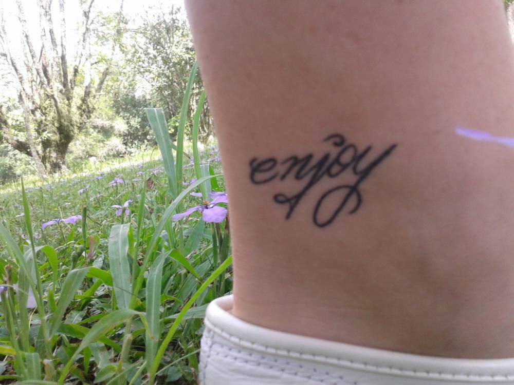 Ankle tattoo saying ‘enjoy’ on Louise, to never