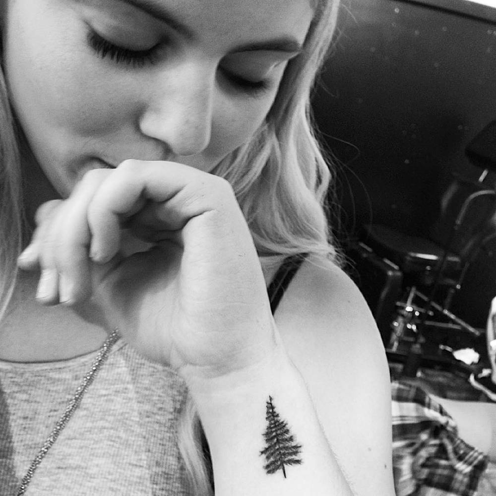 Wrist tattoo of a pine tree.