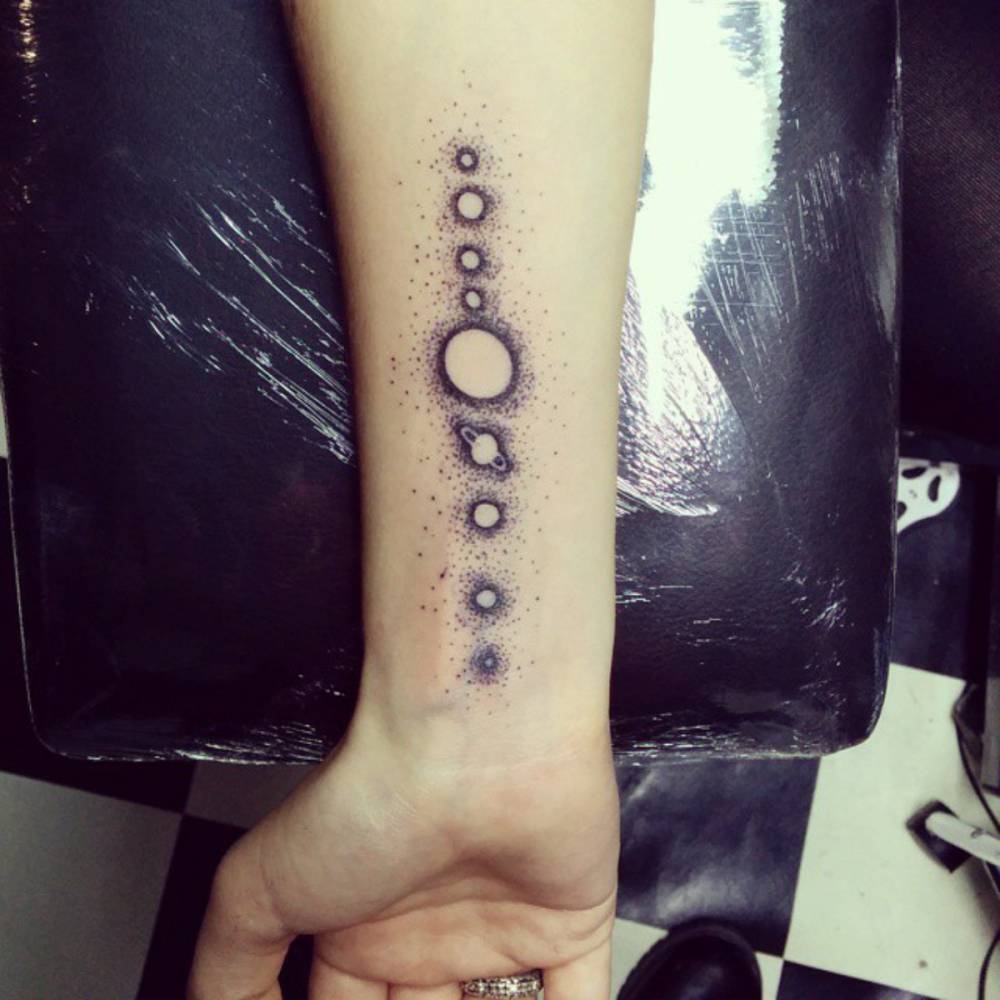 Little forearm tattoo of the 9 of the solar