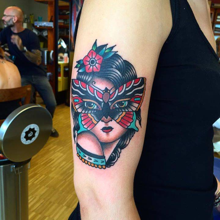 Traditional style woman with butterfly mask tattoo on