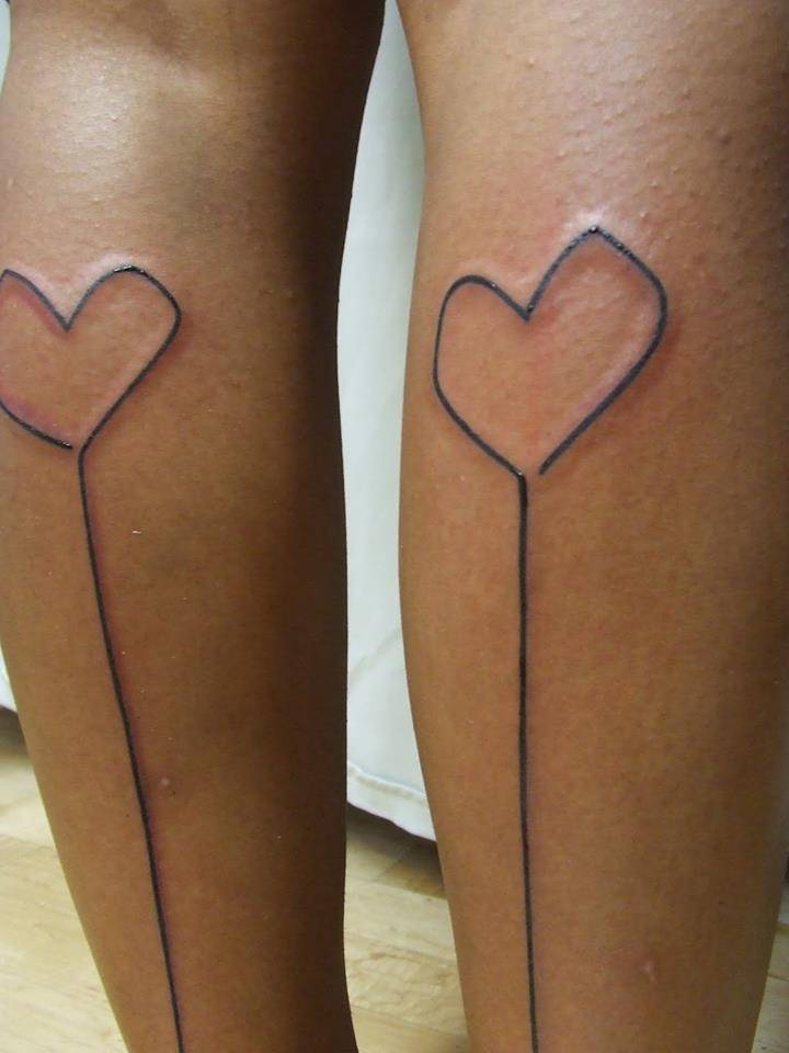 Matching line art tattoos on both calfs.