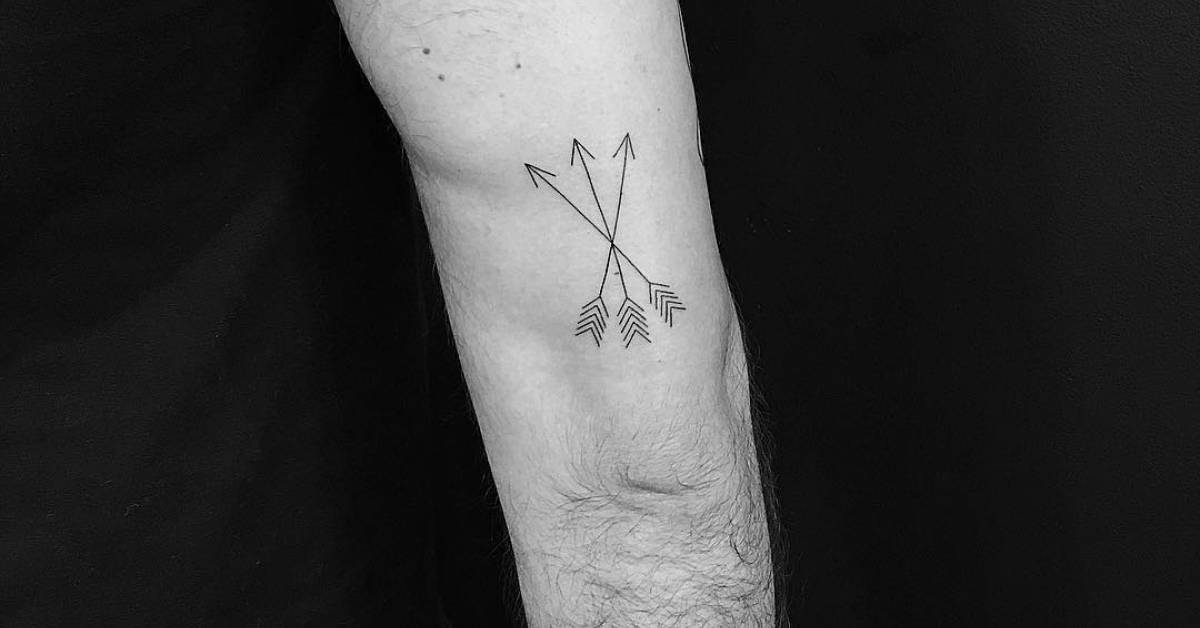 Three arrows tattoo on the back of the right arm.