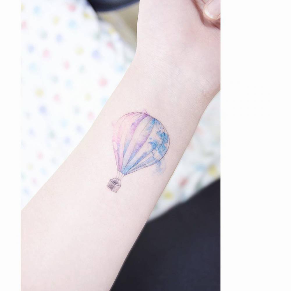 Watercolor air ballon tattoo on the left inner forearm.