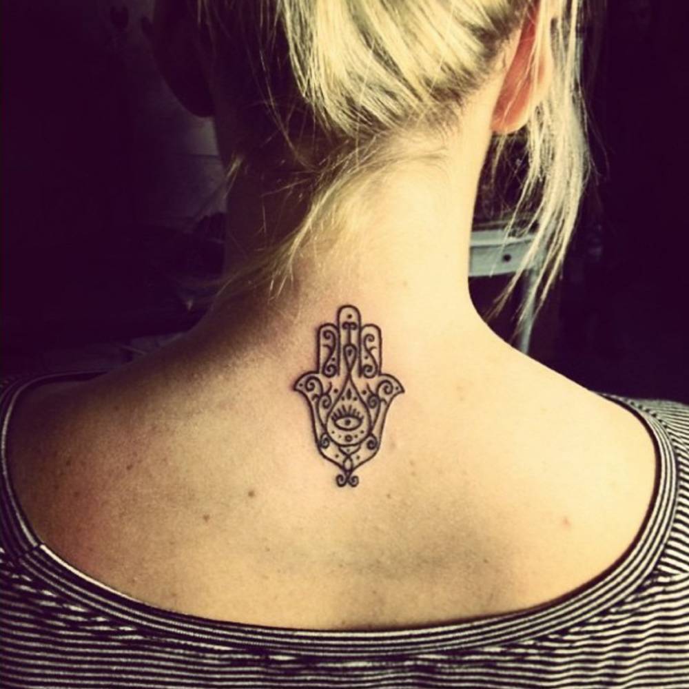 Upper back tattoo of a hamsa by tattoo artist Craigy