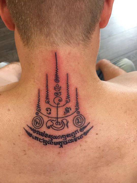 Sak Yant style tattoo on the upper back.