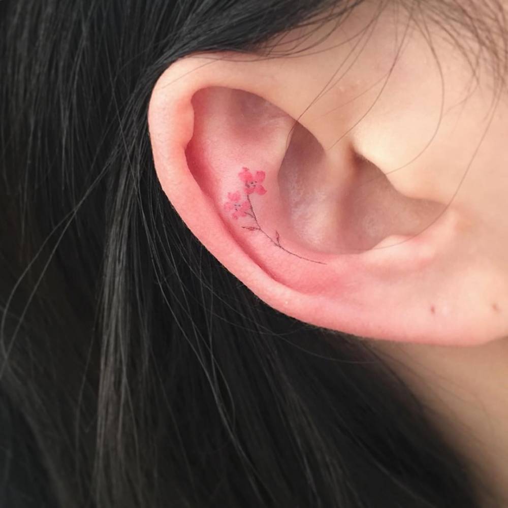Tiny flower tattoo on the ear.