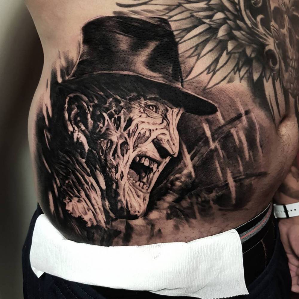 Black and grey Freddy Krueger tattoo on the stomach.