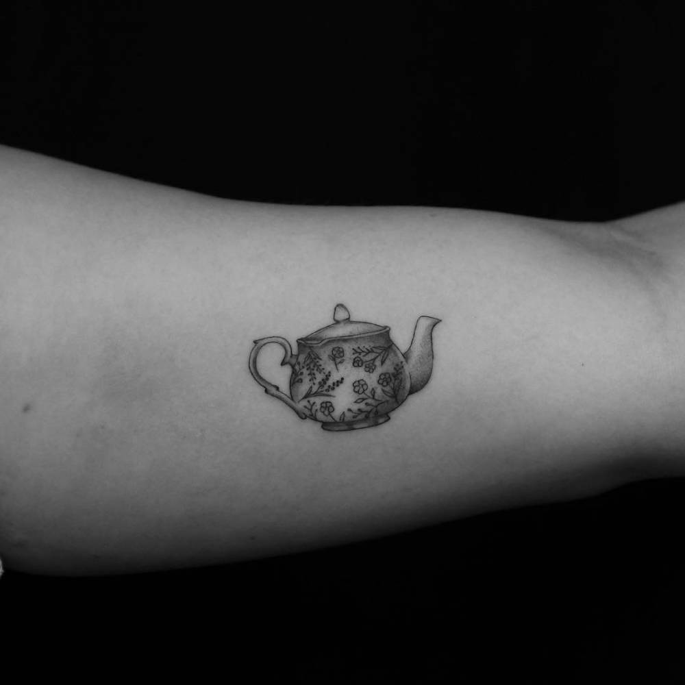 Teapot tattoo on the left inner arm.