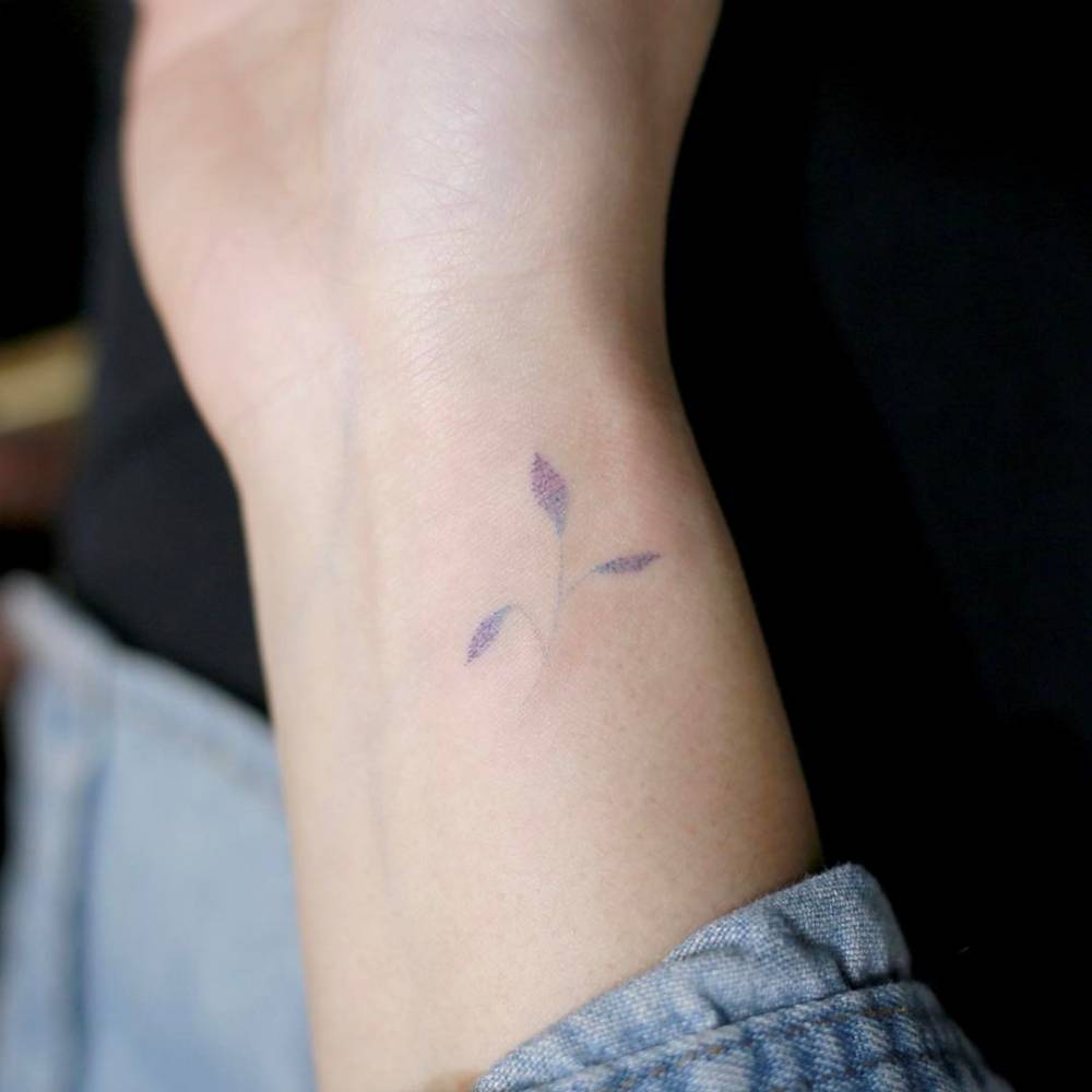 Hand poked flower tattoo on the inner wrist.