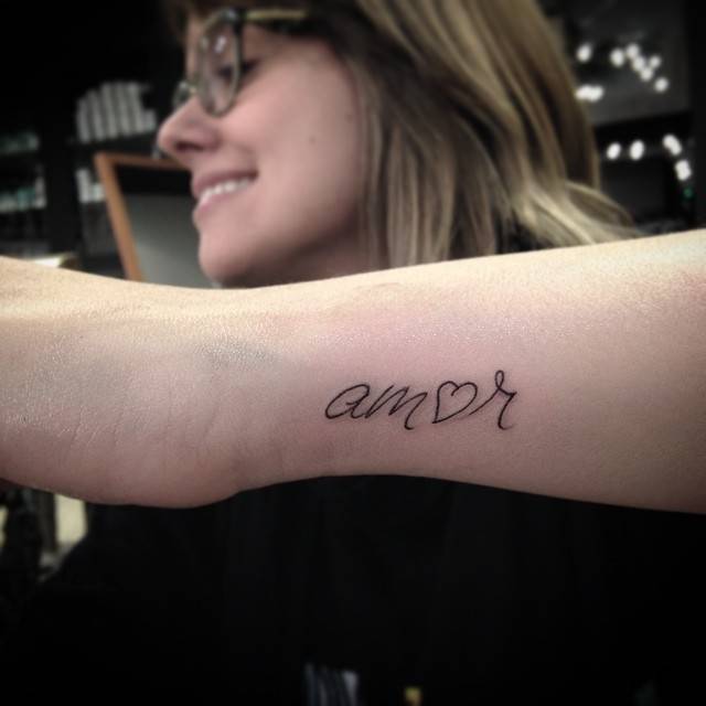"Amor" tattoo on the wrist.