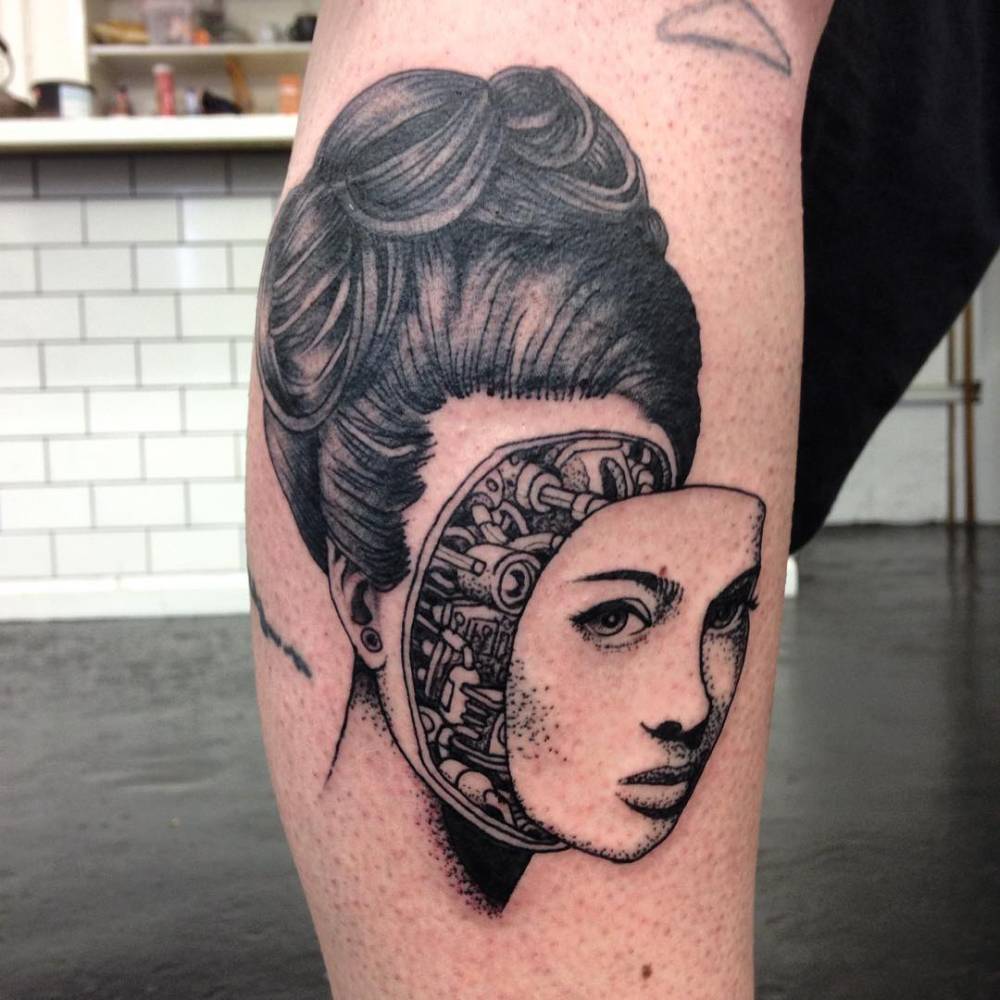 Humanoid robot lady tattoo on the lower leg.
