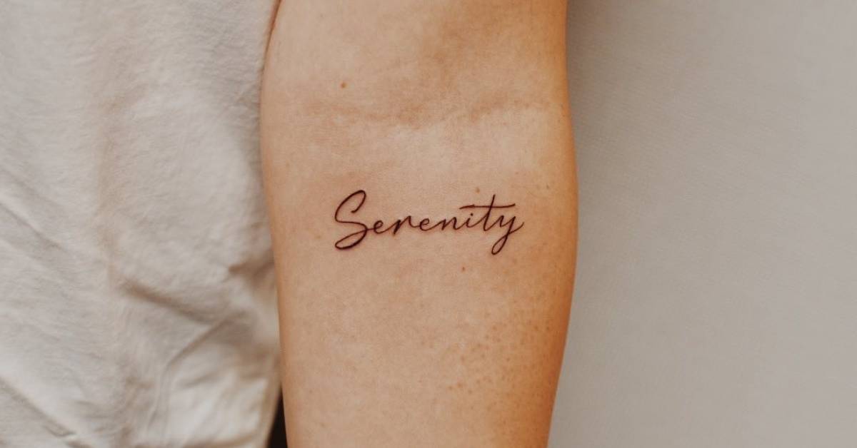 "Serenity" lettering tattoo on the inner forearm