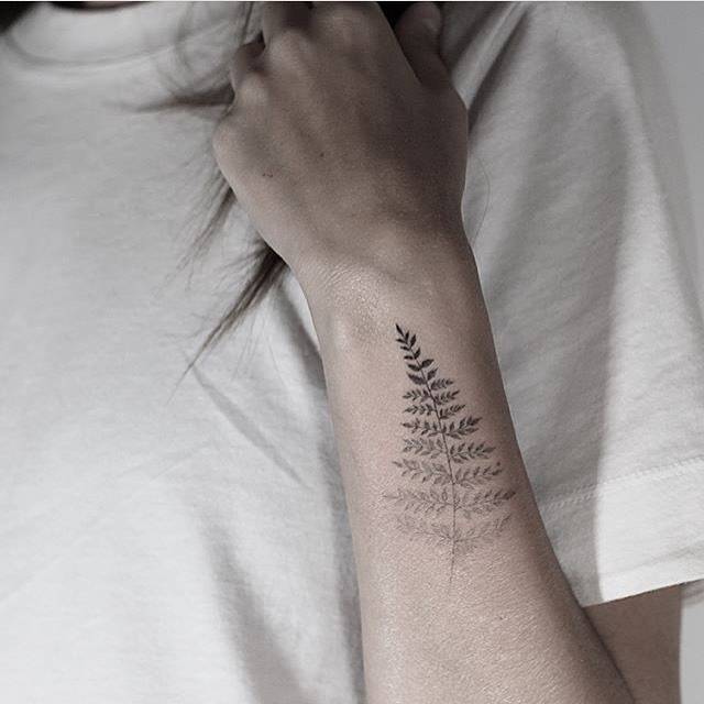 Fern leaf spectrum tattoo on the left forearm.