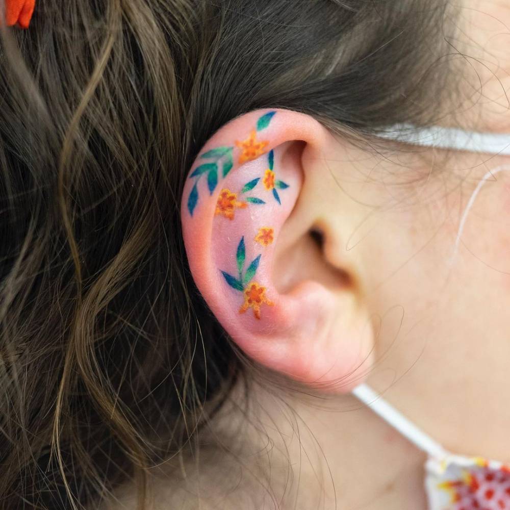 Illustrative flower tattoo on the ear.