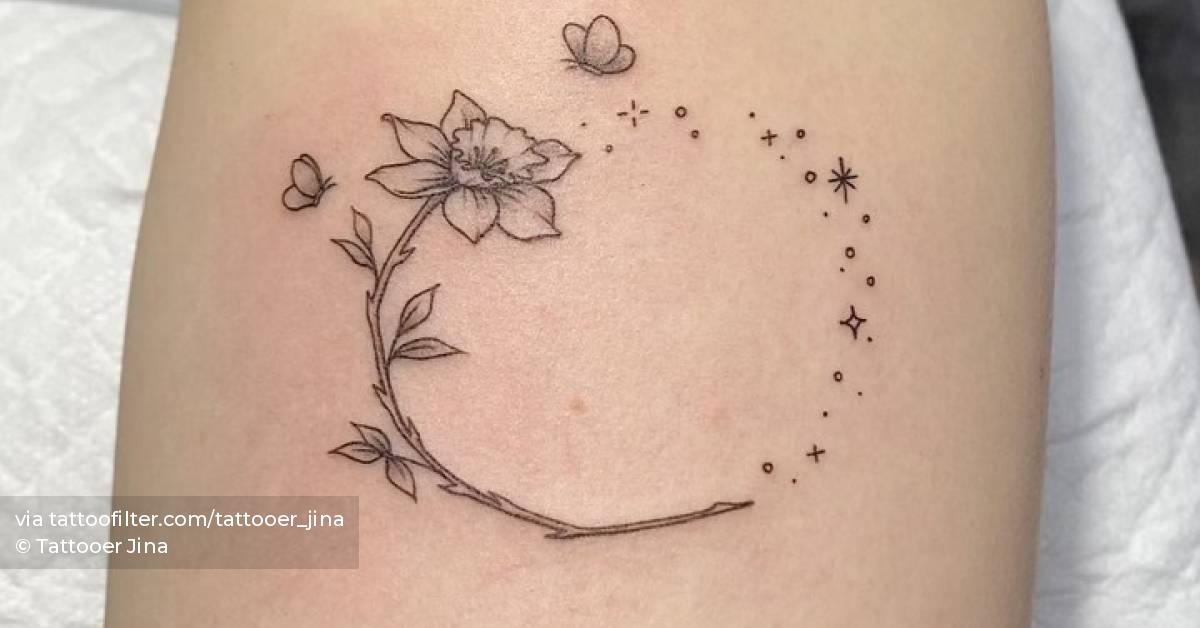 Fine line narcissus flower tattoo on the upper arm