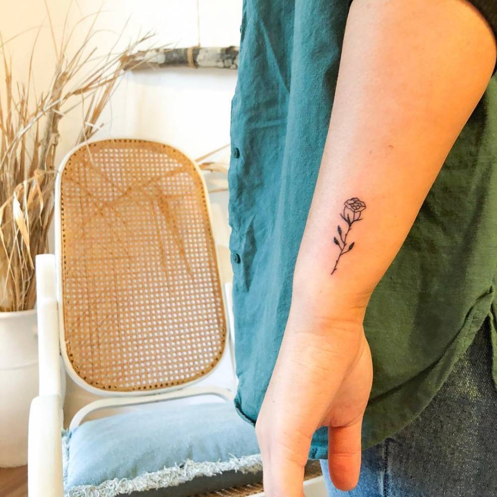 Fine line rose tattoo on the wrist.