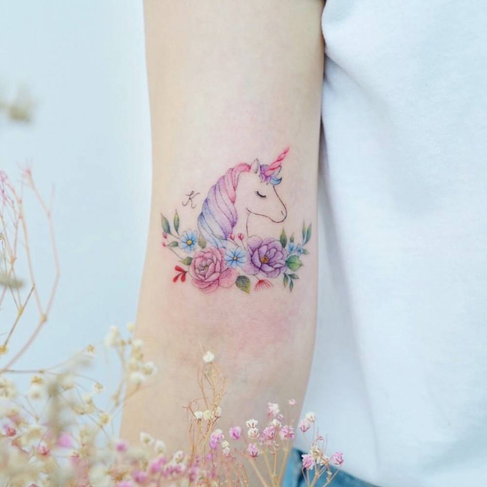 Watercolor unicorn tattoo on the bicep.