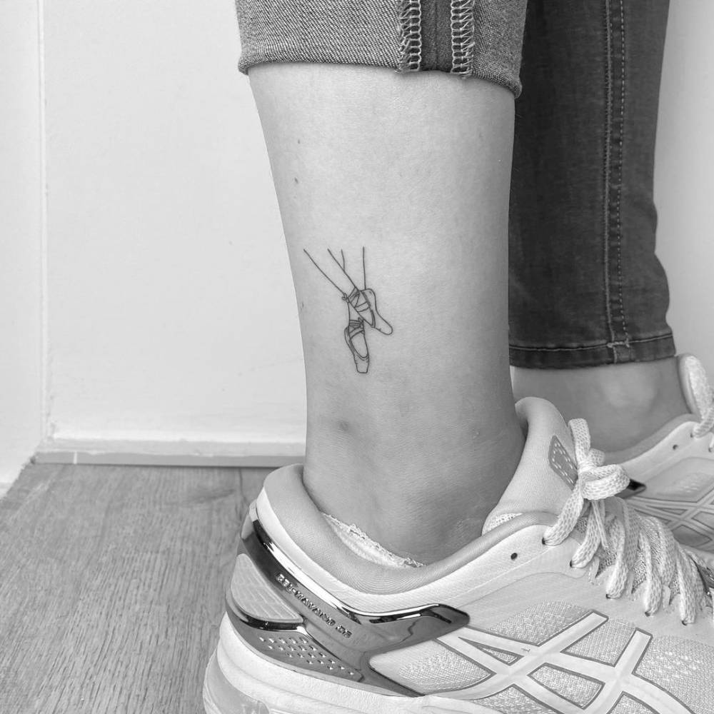 Fine line ballet shoes tattoo on the ankle.