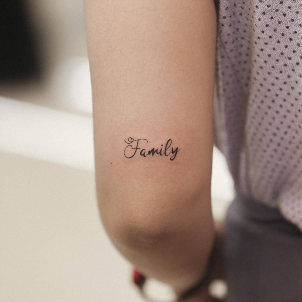 "Family" lettering tattoo on the tricep.