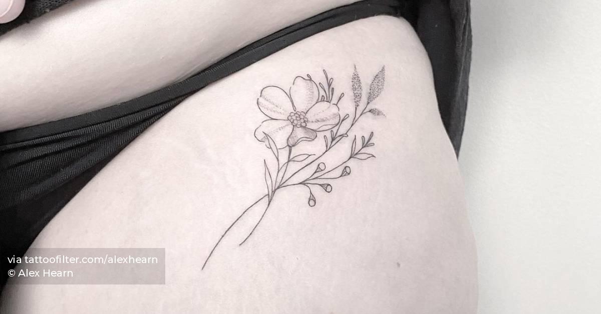 Fine line flower tattoo on the pelvis.