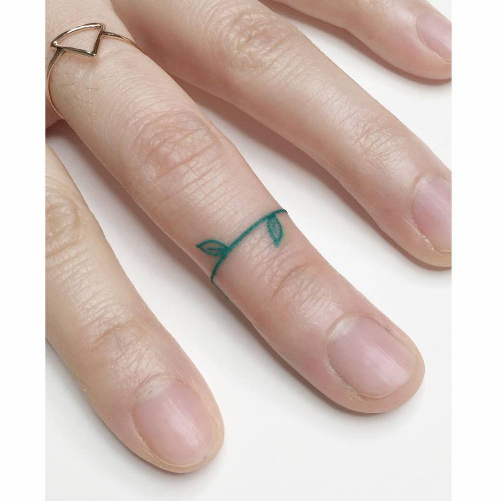 Minimalist green leaf ring tattoo.