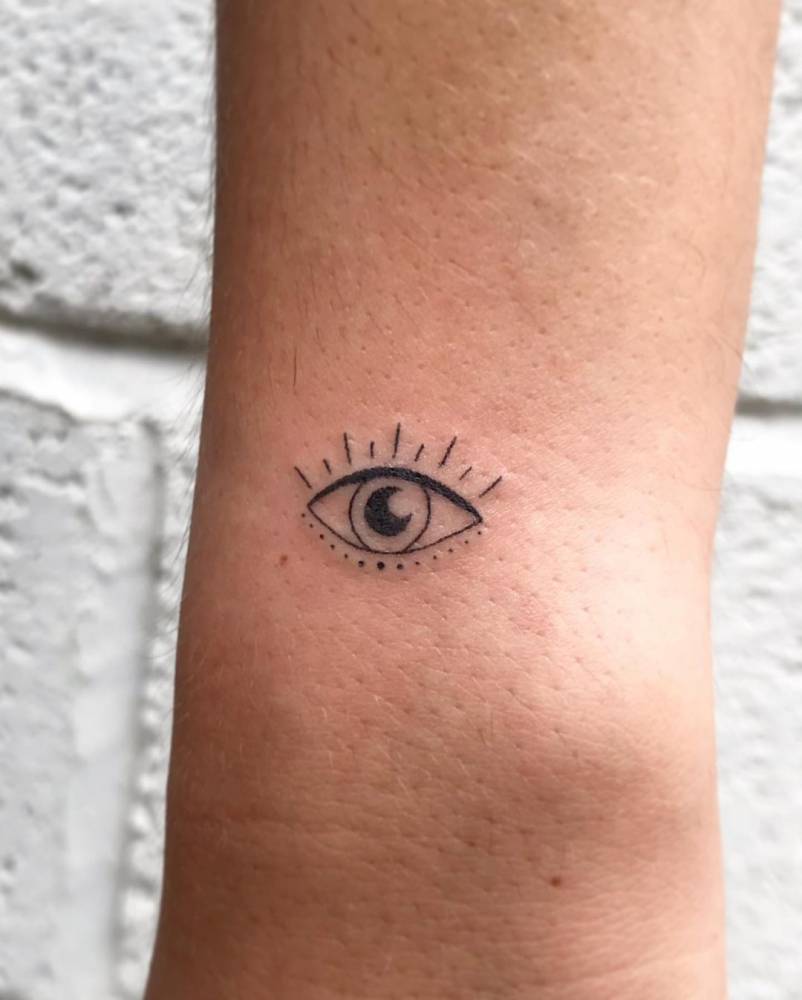 Hand poked evil eye tattoo on the wrist.