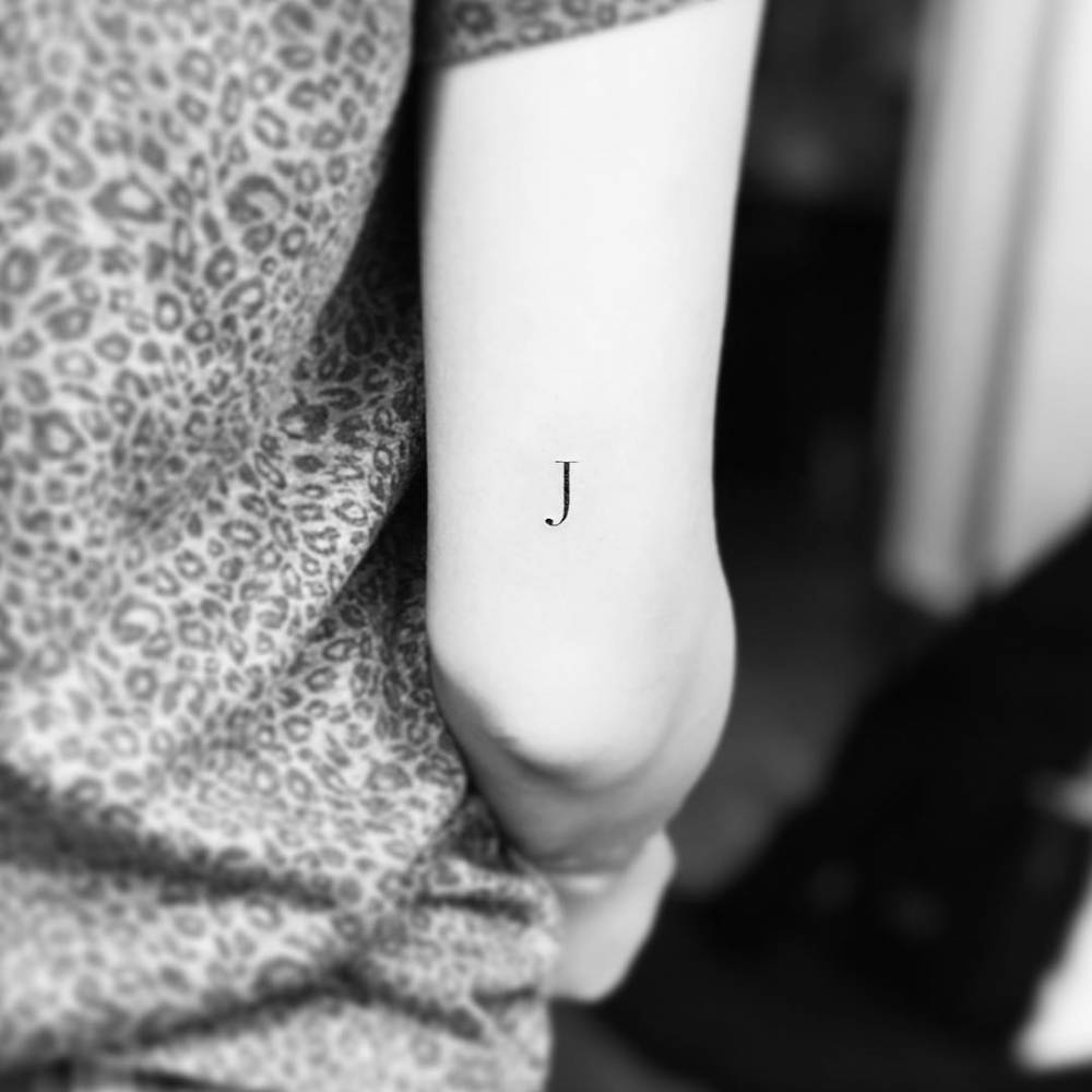 J letter tattoo on the back of the right arm. J for J